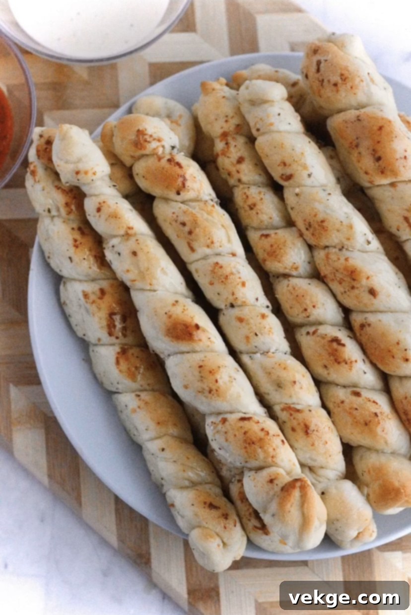 Golden Cheesy Swirls 2 Golden brown cheesy bread twists on a baking sheet, ready to be served, evoking an Italian restaurant feel.