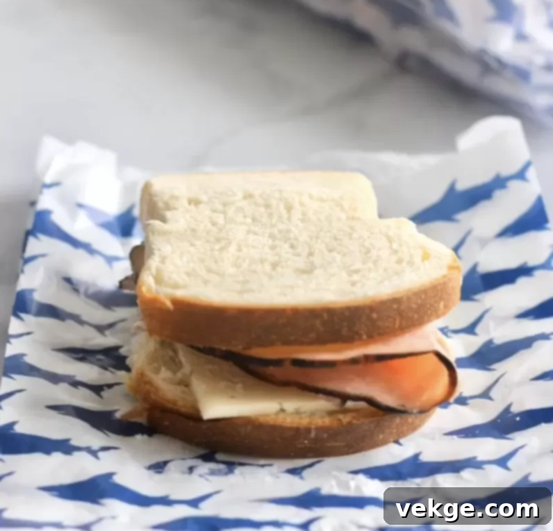 Freezer Sandwich Hacks 4 Stacked ham and cheese sandwiches ready to be wrapped for the freezer.
