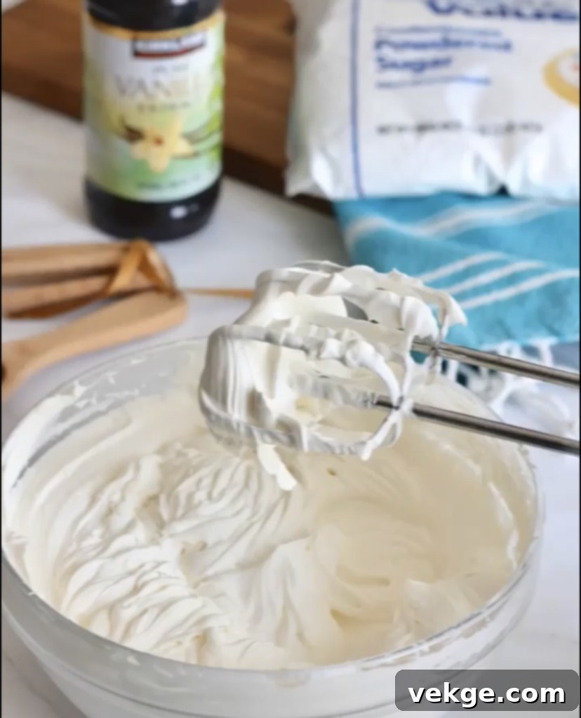 A close-up shot of a pristine bowl filled with freshly whipped, fluffy cream, ready to adorn any sweet treat.
