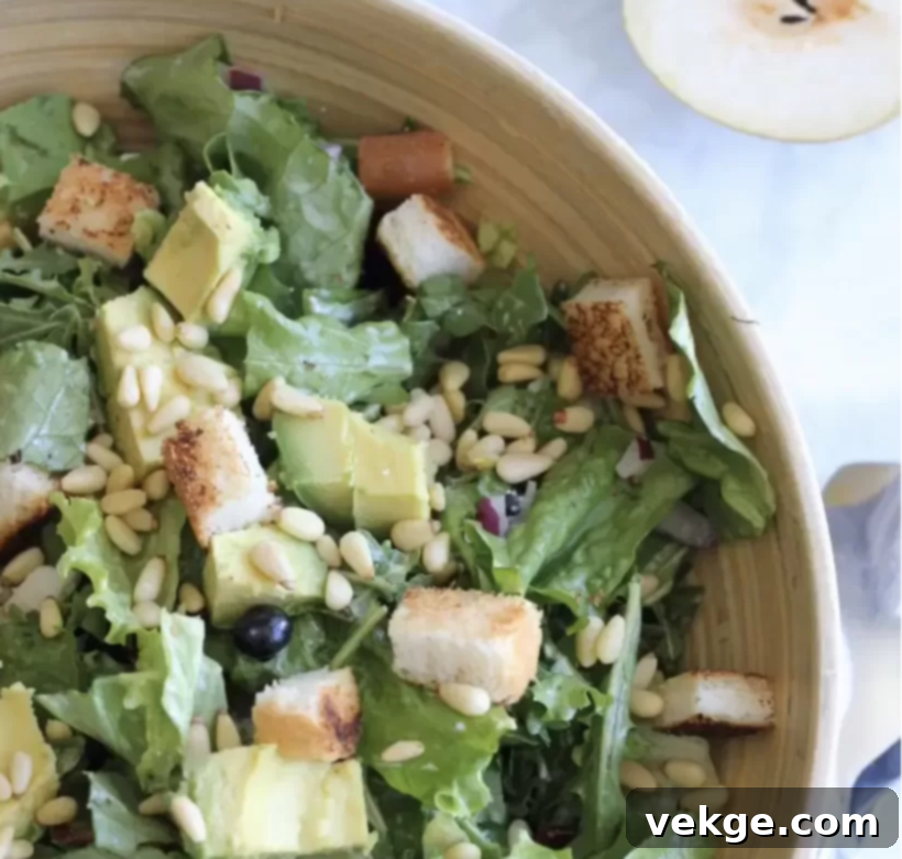 A delicious Sweet and Savory Green Salad with a light dressing, presented beautifully in a stylish bowl.