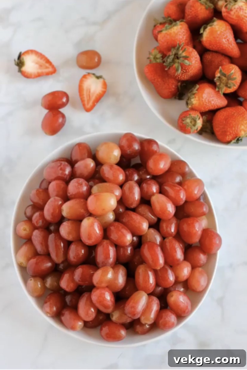 Vibrant Harvest Cleanse 2 Freshly washed grapes and berries in a colander, glistening with water droplets, after being cleaned with the vinegar wash.