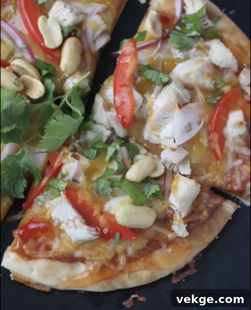 A close-up shot of a Thai Chicken Pita Pizza, garnished with fresh cilantro and crushed peanuts, showcasing a vibrant and appealing texture.
