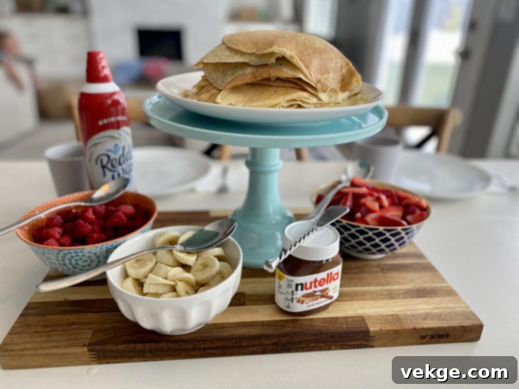 A stack of perfectly cooked sourdough discard crepes with various toppings in the background.