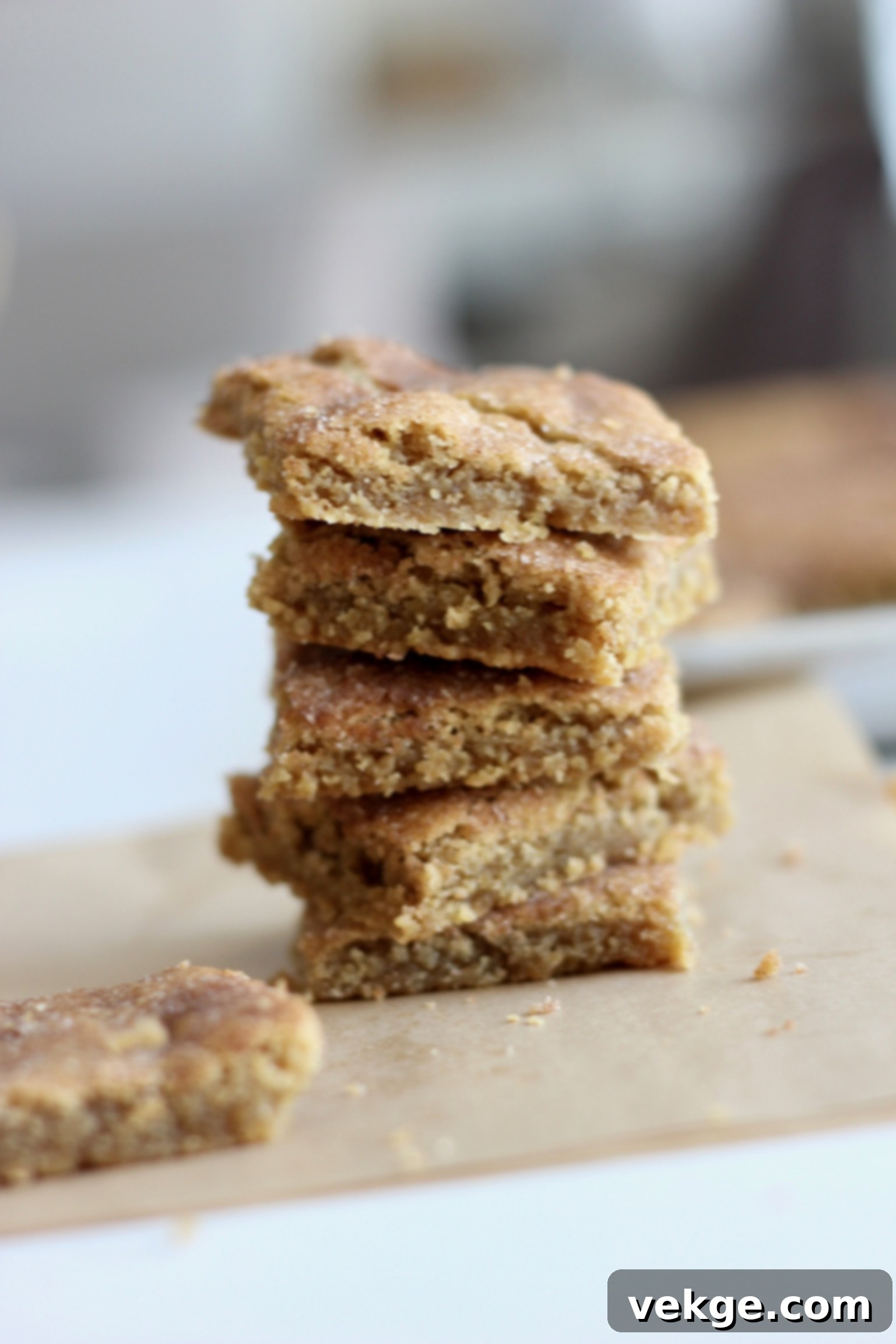 A close-up of a stack of freshly baked Snickerdoodle Bars, showcasing their soft, chewy texture and cinnamon-sugar topping.